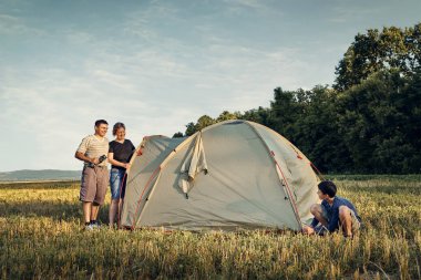 Aile gün batımı, güzel yaz manzara çadır kampı kurmak. Turizm, doğa yürüyüşü ve seyahat.