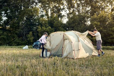 Aile gün batımı, güzel yaz manzara çadır kampı kurmak. Turizm, doğa yürüyüşü ve seyahat.
