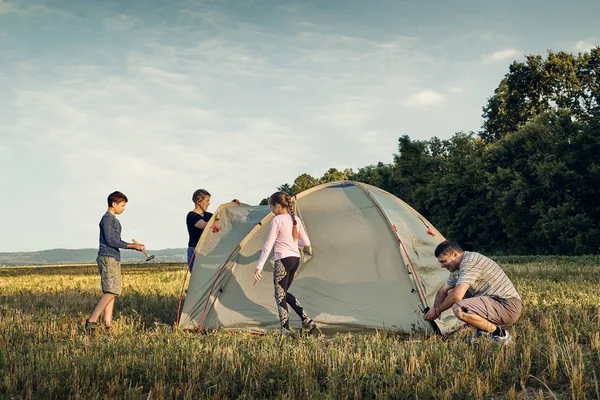 Famille installer un camp de tente au coucher du soleil, beau paysage d'été. Tourisme, randonnées et voyages dans la nature . — Photo
