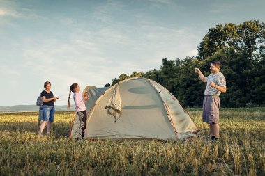 Aile gün batımı, güzel yaz manzara çadır kampı kurmak. Turizm, doğa yürüyüşü ve seyahat.