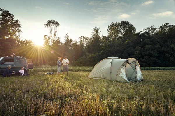 Familia estableció campamento de carpa al atardecer, hermoso paisaje de verano. Turismo, senderismo y viajes en la naturaleza . —  Fotos de Stock