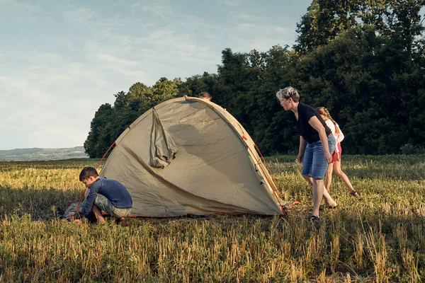 Famille installer un camp de tente au coucher du soleil, beau paysage d'été. Tourisme, randonnées et voyages dans la nature . — Photo