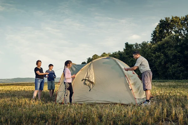 Famille installer un camp de tente au coucher du soleil, beau paysage d'été. Tourisme, randonnées et voyages dans la nature . — Photo