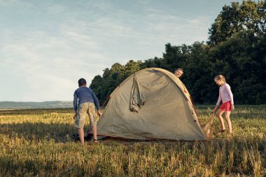 Aile gün batımı, güzel yaz manzara çadır kampı kurmak. Turizm, doğa yürüyüşü ve seyahat.