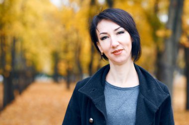 Sonbahar şehir parkında poz veren güzel kadın, sonbahar mevsimi, sarı yapraklar