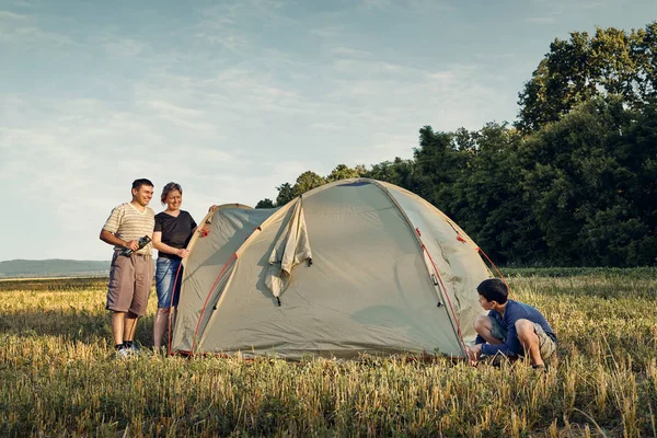 Famille installer un camp de tente au coucher du soleil, beau paysage d'été. Tourisme, randonnées et voyages dans la nature . — Photo