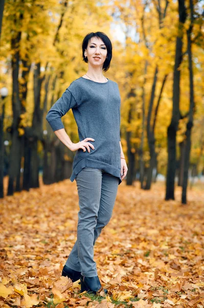 Красивая женщина позирует в осеннем городском парке, осенний сезон, желтые листья — стоковое фото