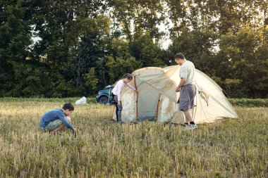 Aile gün batımı, güzel yaz manzara çadır kampı kurmak. Turizm, doğa yürüyüşü ve seyahat.