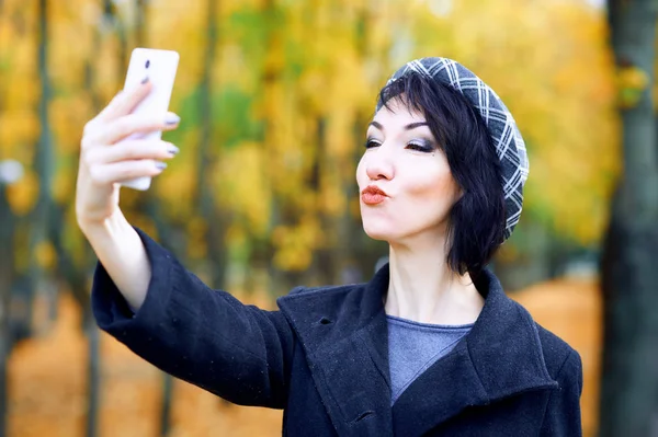 Gyönyörű nő vesz selfie a smartphone és a szórakozás ősszel városi park, őszi szezon, sárga levelek — Stock Fotó