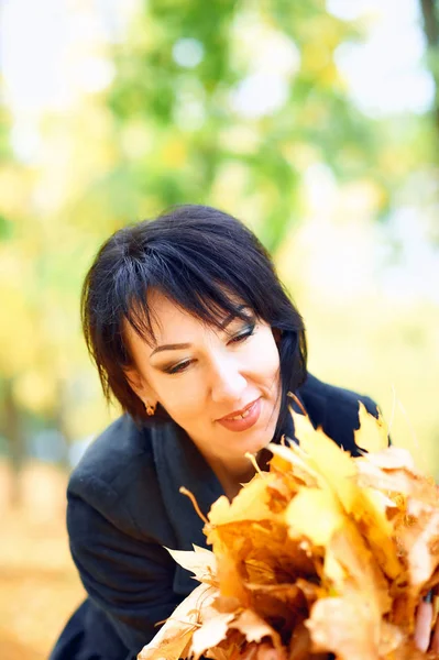 सुंदर महिला शरद ऋतु शहर पार्क में पीले पत्तियों के साथ पोज़िंग, शरद ऋतु — स्टॉक फ़ोटो, इमेज