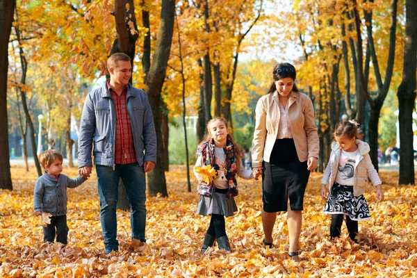 Bonne famille ayant des vacances dans le parc de la ville d'automne. Enfants et parents posant, souriant, jouant et s'amusant. Feuilles et arbres jaune vif — Photo