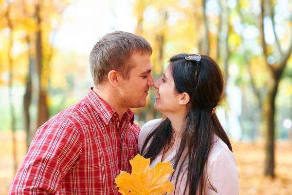 Retrato de casal feliz no parque da cidade de outono. Árvores e folhas amarelas brilhantes — Fotografia de Stock