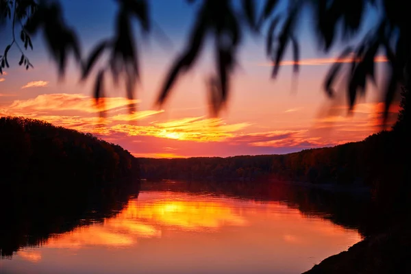 Prachtige zonsondergang in de herfst seizoen-bomen silhouet in de buurt van een rivier, fel zonlicht — Stockfoto