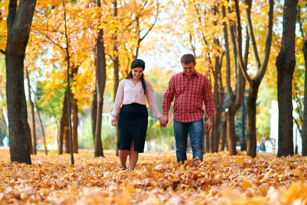 Lyckligt par går i höst stadsparken. Ljust gula träd och löv — Stockfoto