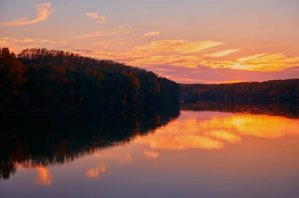 Prachtige zonsondergang in de herfst seizoen-bomen silhouet in de buurt van een rivier, fel zonlicht — Stockfoto