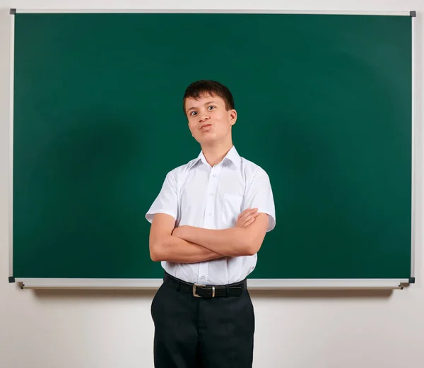 Porträt eines Schuljungen, der auf Tafel-Hintergrund posiert - zurück — Stockfoto