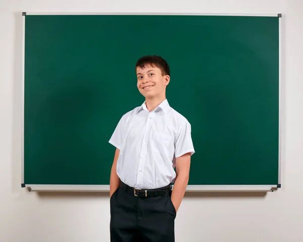 Porträtt av en skol pojke som poserar på Blackboard Background-tillbaka till skolan och utbildningskonceptet — Stockfoto