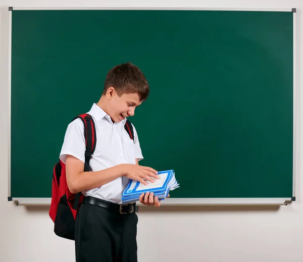 Portret chłopca szkolnego stwarzające z plecaka i materiałów szkolnych, tablica tła-powrót do szkoły i koncepcji edukacji — Zdjęcie stockowe