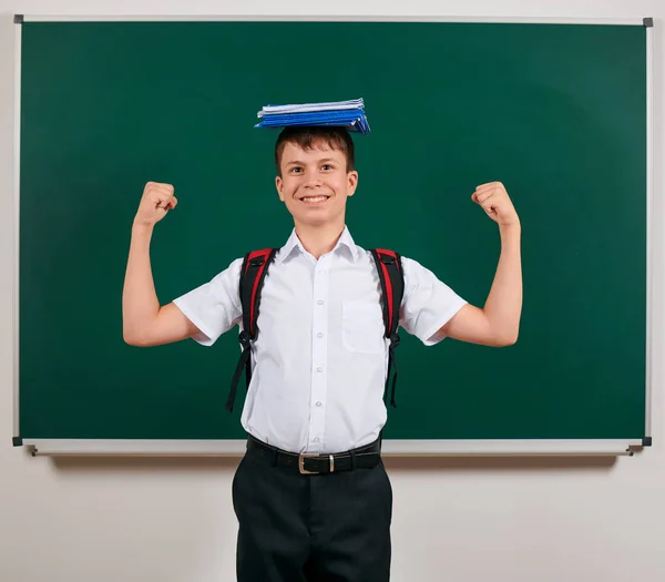 Porträt eines Schuljungen, der mit Rucksack und Schulmaterial posiert, Tafel-Hintergrund - zurück zu Schule und Bildungskonzept — Stockfoto