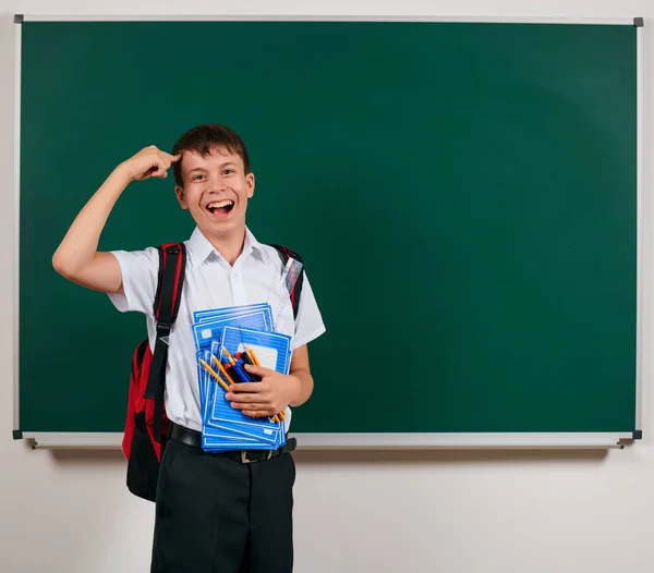 Portrait d'un écolier posant avec sac à dos et fournitures scolaires, fond tableau noir - concept de retour à l "école et d" éducation — Photo