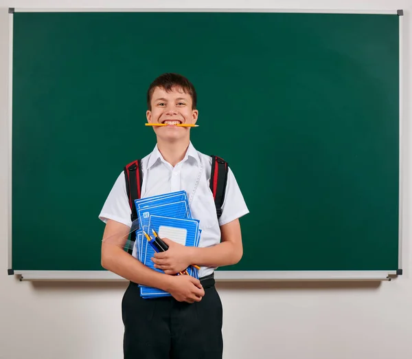 Portrait d'un écolier posant avec sac à dos et fournitures scolaires, fond tableau noir - concept de retour à l "école et d" éducation — Photo