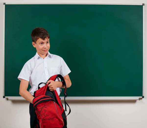 Πορτραίτο ενός αγοριού που έψαχνε για σχολικές προμήθειες στο σακίδιο του, το φόντο του μαυροπίνακα-πίσω στο σχολείο και την εκπαίδευση — Φωτογραφία Αρχείου