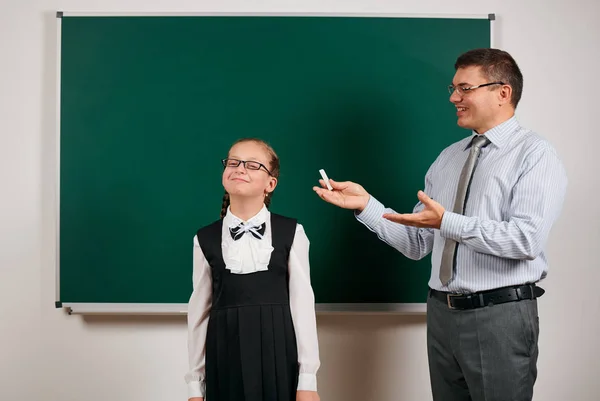 Portrait of a teacher and schoolgirl like as excellent pupil, posing at blackboard background - back to school and education concept — Stock Photo, Image