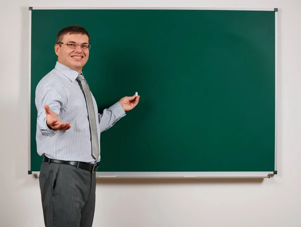 Retrato de un hombre vestido como un maestro de escuela en traje de negocios, posando en el fondo de pizarra aprendizaje y concepto de educación —  Fotos de Stock