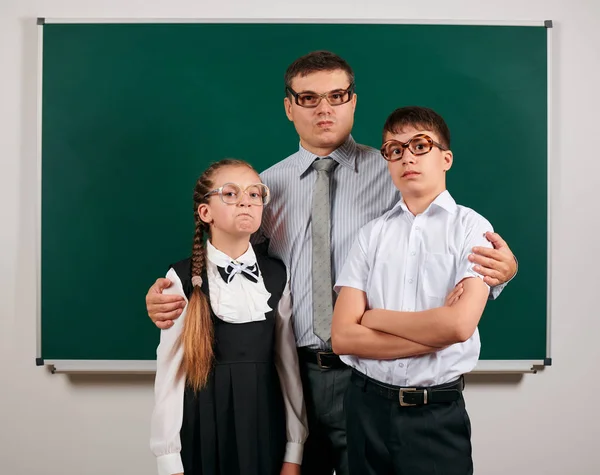 Portret van een leraar, school jongen en schoolmeisje met ouderwetse brillen poseren op Blackboard achtergrond-terug naar school en onderwijsconcept — Stockfoto