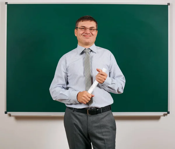 Портрет чоловіка, одягненого як шкільний вчитель у діловий костюм, позує на дошці на фоні навчання та освіти концепції — стокове фото