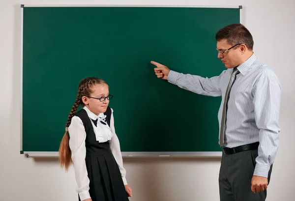 Professor irritado gritar a estudante, posando em fundo quadro-negro - de volta à escola e conceito de educação — Fotografia de Stock