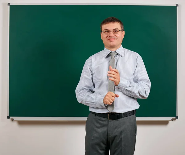 Potret seorang laki-laki berpakaian seperti seorang guru sekolah dalam pakaian bisnis, berpose di latar belakang papan tulis belajar dan konsep pendidikan — Stok Foto