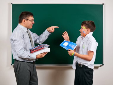 Düşük disiplinli bir öğretmen ve komik bir öğrencinin portresi. Öğrenci çok duygusal, eğlenceli ve çok mutlu, kara tahta arka planda poz - geri okul ve eğitim kavramı
