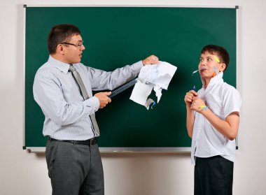 Düşük disiplinli bir öğretmen ve komik bir öğrencinin portresi. Öğrenci çok duygusal, eğlenceli ve çok mutlu, kara tahta arka planda poz - geri okul ve eğitim kavramı