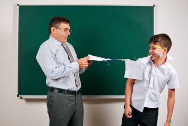 Düşük disiplinli bir öğretmen ve komik bir öğrencinin portresi. Öğrenci çok duygusal, eğlenceli ve çok mutlu, kara tahta arka planda poz - geri okul ve eğitim kavramı