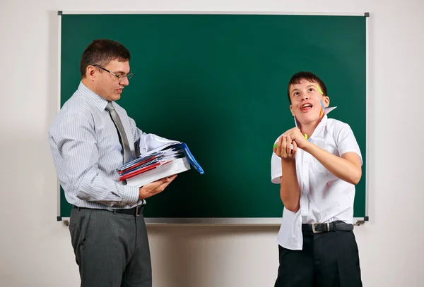 Portret van een leraar en grappige school jongen met lage discipline. Leerling zeer emotioneel, plezier en zeer gelukkig, poseren op Blackboard achtergrond-terug naar school en onderwijsconcept — Stockfoto