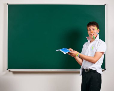Komik öğrenci portresi. Okul çocuk çok duygusal, eğlenceli ve çok mutlu, kara tahta arka plan sahip - geri okul ve eğitim kavramı