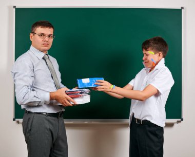 Düşük disiplinli bir öğretmen ve komik bir öğrencinin portresi. Öğrenci çok duygusal, eğlenceli ve çok mutlu, kara tahta arka planda poz - geri okul ve eğitim kavramı