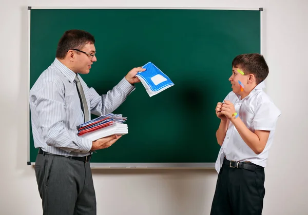 Portret van een leraar en grappige school jongen met lage discipline. Leerling zeer emotioneel, plezier en zeer gelukkig, poseren op Blackboard achtergrond-terug naar school en onderwijsconcept — Stockfoto