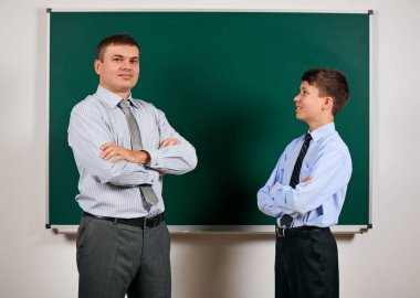 Bir adam ve çocuk kara tahta arka plan yakın bir iş elbisesi giymiş Portresi - öğrenme ve eğitim kavramı