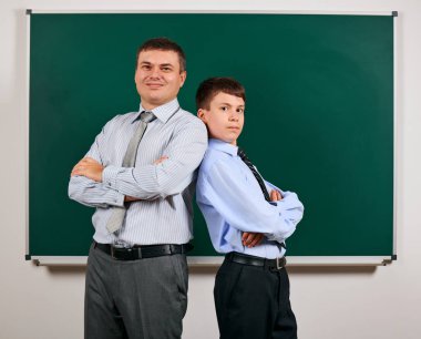 Bir adam ve çocuk kara tahta arka plan yakın bir iş elbisesi giymiş Portresi - öğrenme ve eğitim kavramı