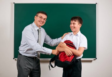 Bir öğretmen ve okul çocuğu kara tahta arka planda oynayan portresi - geri okul ve eğitim kavramı