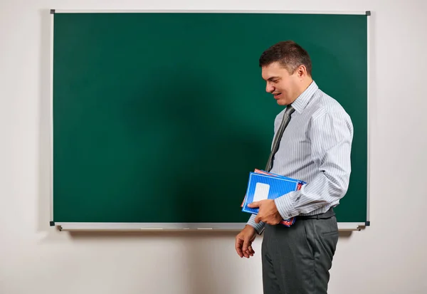 Portrait of a man as a teacher, posing at school board background - learning and education concept — Stock Photo, Image
