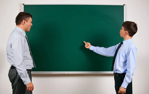 Portrait of a man and boy dressed in a business suits near blackboard background, they having fun - learning and education concept — Stock Photo, Image