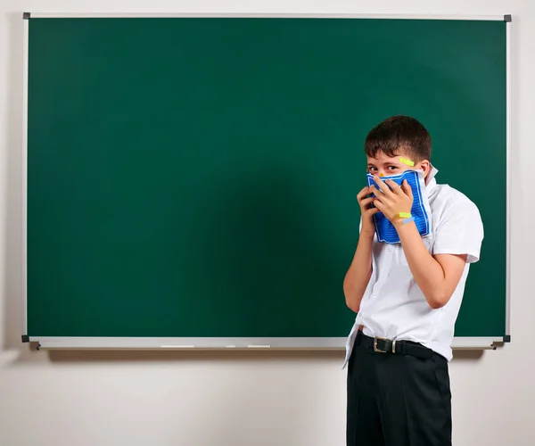 Retrato de aluno engraçado. Menino da escola muito emocional, se divertindo e muito feliz, fundo blackboard - de volta ao conceito de escola e educação — Fotografia de Stock