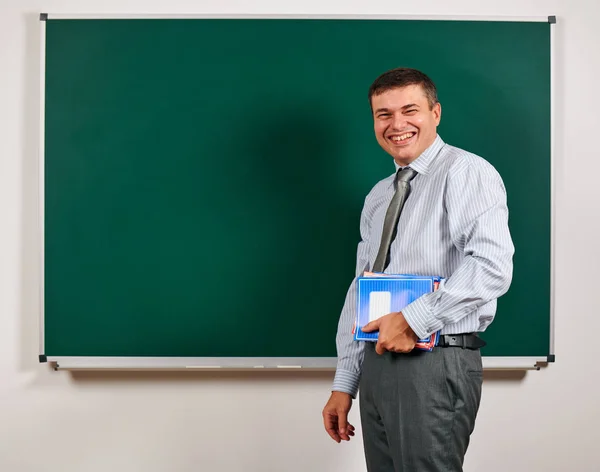 Portrait of a man as a teacher, posing at school board background - learning and education concept — Stock Photo, Image
