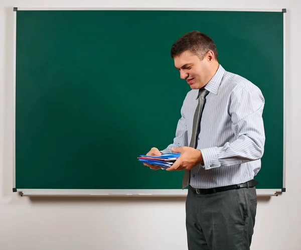 Portrait of a man as a teacher, posing at school board background - learning and education concept — Stock Photo, Image