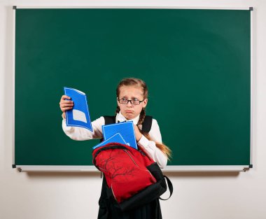 Sırt çantası ve kara tahta arka plan yakın okul malzemeleri ile bir kız öğrenci portresi - geri okul ve eğitim kavramı