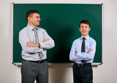 Bir adam ve çocuk kara tahta arka plan yakın bir iş elbisesi giymiş Portresi - öğrenme ve eğitim kavramı