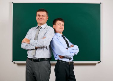 Bir adam ve çocuk kara tahta arka plan yakın bir iş elbisesi giymiş Portresi - öğrenme ve eğitim kavramı
